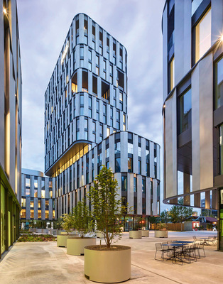 Die elegant geschwungene Fassade ist ein besonderes Merkmal des Optinieo. Über fast alle Stockwerke wurden zudem begrünte Loggien und Terrassen in die Fassadenstruktur integriert.