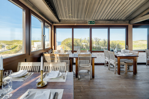 Filigrane, großflächige Fensterprofile aus Aluminium ermöglichen einen ungehinderten Ausblick auf die schöne Küsten- und Dünenlandschaft der Nordseeinsel Sylt.