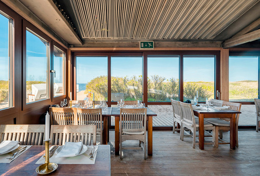 Filigrane, großflächige Fensterprofile aus Aluminium ermöglichen einen ungehinderten Ausblick auf die schöne Küsten- und Dünenlandschaft der Nordseeinsel Sylt.