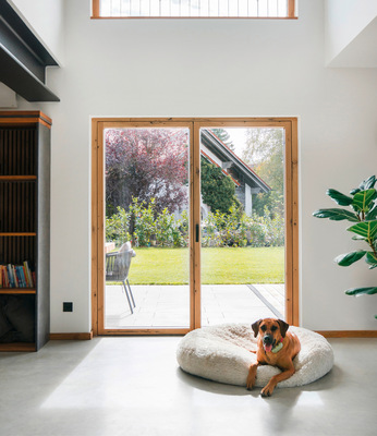 Die warme Ausstrahlung der edlen Wildeiche zieht sich durch den gesamten Wohnraum und schafft eine behagliche Atmosphäre. Der gemütliche Rückzugsort, das Spiel aus Holz und Sichtbeton und der schwebende Kamin verleihen dem Raum modernen Komfort und eine zeitlose Eleganz.