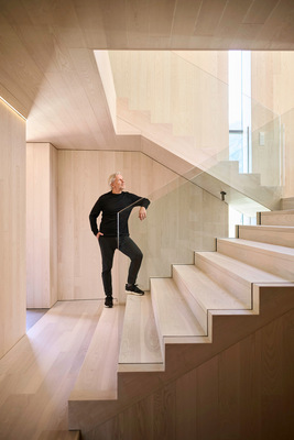 Der Treppenraum wirkt wie aus einem Guss, da alle Wände, Decken, Böden und Treppenläufe mit weiß geölter Esche verkleidet sind. Das transparente Geländer verstärkt diesen Eindruck.