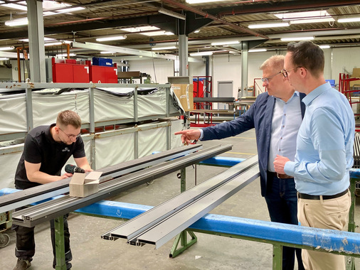 Für die Montage am Element bereitet Metallbauer Julian Frieling unter den Augen von Marcus Müller und Feldhaus Projektleiter Timo Hüwe (v.li.n.re.) das Unterbauprofil in der Fertigung vor.