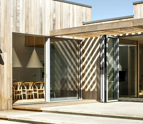 Die Aluminiumprofile der Fenster und Glas-Faltwände sind in dezentem Hellgrau ­gehalten, das zu der Zedernholzfassade passt, die im Laufe der Zeit eine natürliche graue Patina erhält.