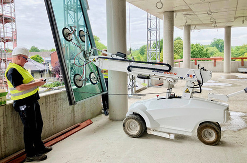 Millimeterangelegenheit: Mit Verfahr- und Hebe­geräten erfolgt das Einbringen der spektakulären Feldhaus Elemente in den Baukörper.