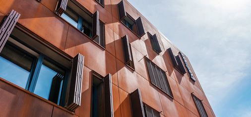Die Faltschiebeläden können in einem 90-Grad-Winkel zur Fassade geöffnet werden und liegen im geschlossenen Zustand bündig an der Fassade an.