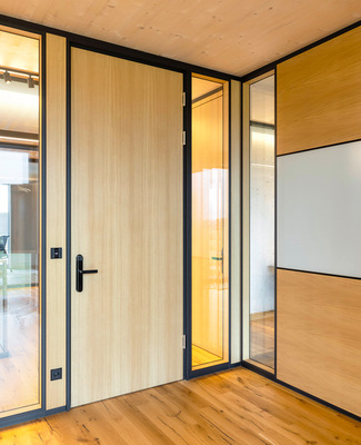 Ebenfalls zum Einsatz kommen nicht-transparente Elemente, hier eines mit integriertem Glas-Whiteboard.