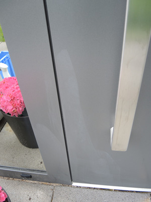 Schaden 2 - Wischspuren: "Unten links Wischspuren von Lösemittel auf dem Türblatt und dem Pfosten" – eine unsachgemäße Reinigung hatte die Pulverbeschichtung angegriffen.