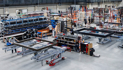 Seit Anfang 2025 ist die Aluminiumfertigung am Standort integriert; im Vergleich zur Kunststofffertigung werden oft größere Elemente bearbeitet, daher sind auf 12 m ausziehbare Schwenktische in der Endmontage notwendig.