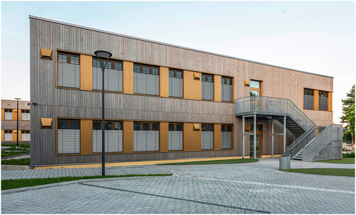 Die neue vierzügige Grundschule für 400 Kinder umfasst drei in vorgefertigter Holzmodulbauweise realisierte Lernhäuser, die sich um ein zentrales Aktionszentrum mit Mensa und Ganztagsbereich gruppieren.