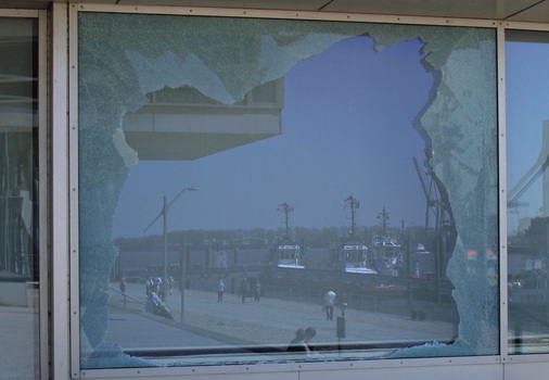 (3) Teile der VSG-Verglasung eines Gebäudeeingangs, der von den angrenzenden Bürobereichen thermisch getrennt ist, nach einem (geplanten) Angriff. Bruchbild: Auf der Druckseite (Außenscheibe) ringförmig und auf der Zugseite (Innenscheibe) sternförmig