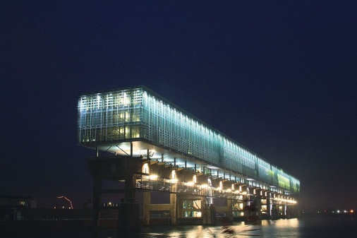Nach dem Slimbouwen-Prinzip erstellte Gebäude sind effizienter als herkömmliche BautenKraanspoor: Gebautes Beispiel in Amsterdam, mit Glas-Doppelfassade, errichtet auf einer ehemaligen Krananlage (Entwurf Trude Hooykaas).