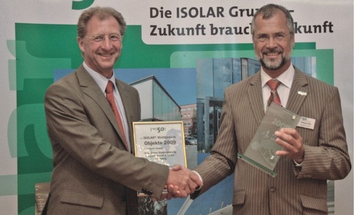Der Gewinner des Isolar Wettbewerbs<br />Den 1. Preis erhielt Wolfgang Wies (re.), Geschäftsführer der Hunsrücker Glasveredelung Wagener GmbH, von Carl Pinnekamp (Teutemacher Glas) ­überreicht.
