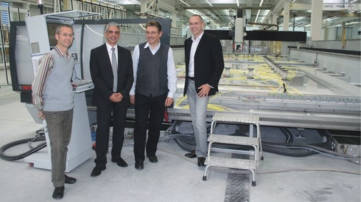 Zufriedene Verarbeiter – zufriedener LieferantVor dem weltweit größten Glasbearbeitungszentrum (v.r.): sedak Geschäftsführer Alexander Morgenroth, Fertigungsleiter Andreas Wenninger, Fabian Ceulemans, Gebietsverkaufsleiter von Intermac und Bruno Kassnel-Henneberg.