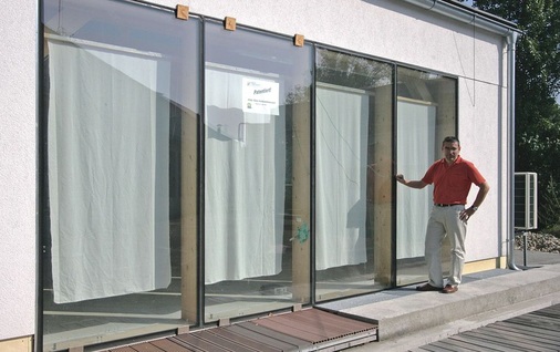 Peter Schober vor einem Testgebäude<br />Hier sind Holz-Glas-Verbundelemente im ­Dauertest zu sehen.