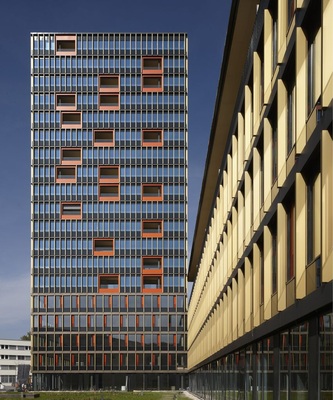 Die goldfarbenen Lisenen differenzieren die Fassade und zeigen die Position der Büro- und Wohnbereiche auf und die Rahmenelemente in Orange umgeben die Loggien.