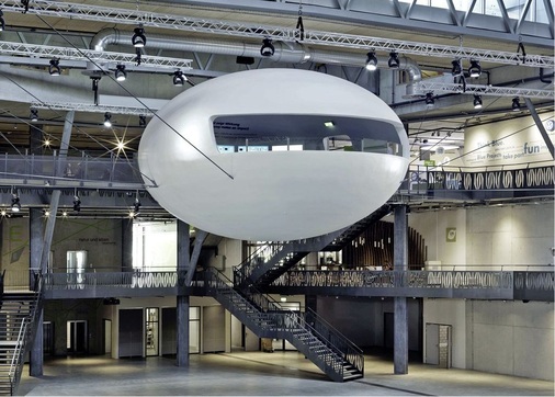 Das Herz des Ausstellungszentrums bildet die dreigeschossige Arena für Nachhaltigkeit. Dort befindet sich schwebend in der Mitte ein Aussichtsraum mit Namen „Cocoon“.