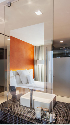 Schönes Detail: Der Spiegel im Badezimmer ist teil einer transparenten, raumteilenden Glasscheibe.