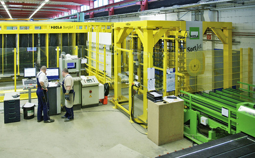 Effizienz und hoher Durchsatz bei der Isolierglas-Fertigung setzt die intelligente Bereitstellung der Gläser vor der Waschmaschine voraus — pünktlich, in korrekter Reihenfolge und Ausrichtung. Das funktioniert wie hier zu sehen auch vollautomatisch. Hier kommt der von A+W DynOpt gesteuerte Hegla SortJet zum Einsatz.