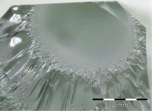 Bruchspiegel an der Glaskante. ­Größe und Radius der glänzenden Fläche ­lassen auf die einwirkende Bruch­energie schließen. Diese lässt sich sehr genau berechnen. In diesem Fall lag die Temperaturdifferenz bei rund 80K. - © Foto: FHV Dornbirn
