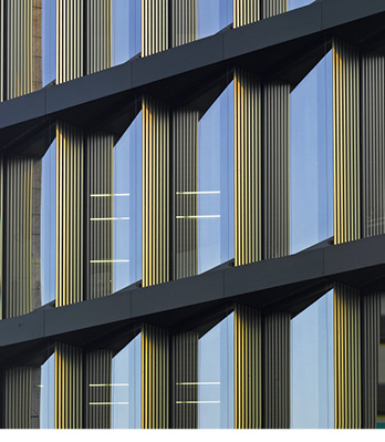 <p>
Hinter den goldfarbene Schallabsorber-Lamellen sind schmale, öffenbare Fensterflügel. Die großen Scheiben sind Festeverglasungen. 
</p> - © Foto: Roland Halbe

