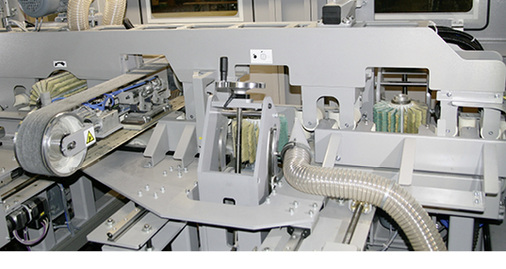 
Kein „Hexenwerk“: Das Q-Fin Innenleben. Zu sehen sind das Aggregat für den Querschliff (l.) und die Schleifbürsten entlang der Rollenführung.
