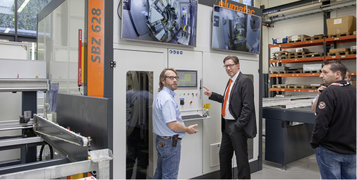 <p>
Ralf Haspel (Mitte, mit orangefarbener Krawatte) und ein Mitarbeiter demonstrieren den Besuchern die neue SBZ 628.
</p>