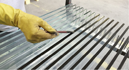 
Nach dem Waschen der Streifen, wird eine Kante mit Silbergelb bestrichen. Die Farbe wird dabei mit dem Pinsel von Hand auf jede Glaskante einzeln aufgetragen.



