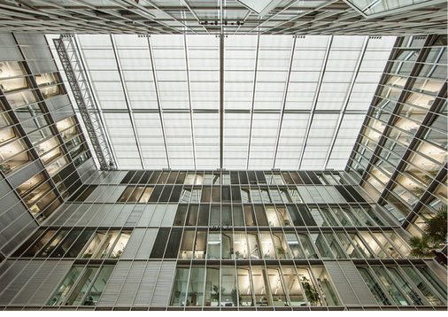 



Mit dem innenliegenden, horizontalen textilen Blendschutz unter dem Glasdach kann der Sonnenschutz im Innenhof des Gebäudes auch bei widrigen Wetterbedingungen mit Regen, Schnee und Sturm erbracht werden.
