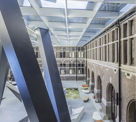 
Das zentrale Atrium mit seinem großzügigen Glasdach grenzt an die Tore der früheren Halle für Löschfahrzeuge (rechts im Bild), die sorgfältig restauriert wurde.

