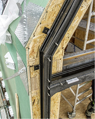 
Der Anschluss der Fassade: Auf die Profile sind bereits Haltesockel für Sonnenschutzelemente aufmontiert. 
