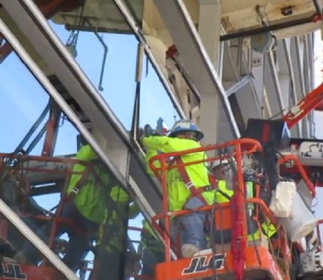 Hier pressen die Monteure eine Isolierglas-Einheit in die Fassadenkonstruktion. Die Scheibe ist mit Edgetech-Spacern ausgestattet.