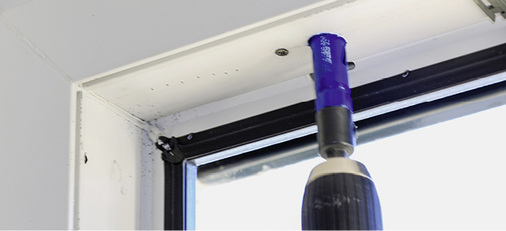 
In einem ausgeglasten Flügel wird mit einem Kronenbohrer eine „Probe“ der Armierung aus dem Glasfalz gezogen. Die erste Schraube, welche die Armierung fixiert, ist um mehr als das doppelte Maß von der Ecke der Schweißnaht entfernt, als die Vorgabe des Profilsystemgebers. Auch ist die Armierung deutlich zu kurz. Dies wird mit einem 2 mm Bohrer getestet, mit dem der Beginn der Armierung geprüft wird. Zu kurze Armierungen führen im Eckbereich zu einem Verdrehen der Profile, sowohl horizontal als auch vertikal. Eine starke Undichtigkeit ist die Folge.
