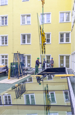 



Komplizierte Montage: Mittels Kranausleger wurden die einzelnen Scheiben über das Bestandsgebäude …
