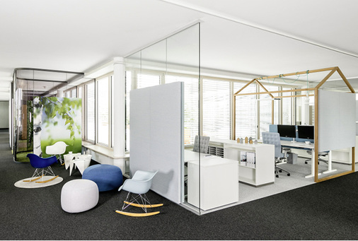 
In Open-Space-Bürowelten gehen die Zonen für Arbeit, Meeting und Rekreation ineinander über. Im Bild schirmen Glaselemente im System fecoplan einen Arbeitsbereich von einer Sitzgruppe ab. 



