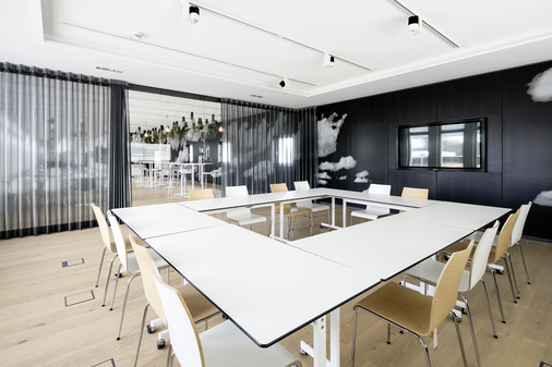 Bei diesem Besprechungsraum werden Schallschutz und Blickschutz durch eine Vorhanganlage gewährleistet. Durch die Glaskonstruktion mit ihren Schiebetüren lässt sich der Raum zudem vergrößern.