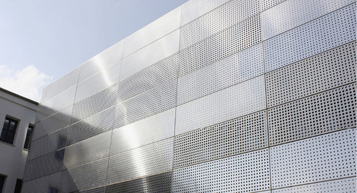 
Die Hebefaltläden sind im geschlossenen Zustand durch die regelmäßigen Spaltmaße nicht auszumachen. Die gelochte Fassadenbeplankung sorgt für den Durchblick.



