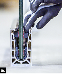 
4: Sind die Scheiben zueinander ausgerichtet, kommen die Spannkeile zum Einsatz. Sie sind über ein Zugband miteinander verbunden und werden über dieses werkzeuglos mit nur einem Handgriff im Glaslager verspannt: Während der montageseitige Spannkeil einfach von Hand festgedrückt wird, zieht man gleichzeitig am Zugband. 



