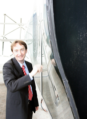 Gartner-Geschäftsführer Klaus Lother an einem Exponat der gebogenen Scheiben für die Elbphilharmonie. - Daniel Mund/GLASWELT