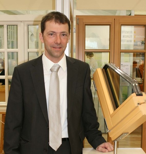 Josef Huber (Huber & Sohn) zeigt die Eigenentwicklung eines passivhaustauglichen Holzfensters mit einem Uw-Wert von 0,79 W/m²K, das ohne zusätzliche Dämmmaterialien hergestellt wird. - Jörr Pfäffinger