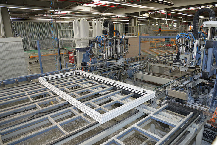 Vollautomatische Fließfertigung: Über Transportstrecken und Software-gesteuerte Shuttles werden die Rahmen und Flügel zwischen den Bearbeitungsstationen weiterbefördert und in intelligente Puffer verbracht. Auch das Isolierglas wird über Puffer mit eindeutigen Stellplätzen in die Verglasung eingesteuert. - A+W