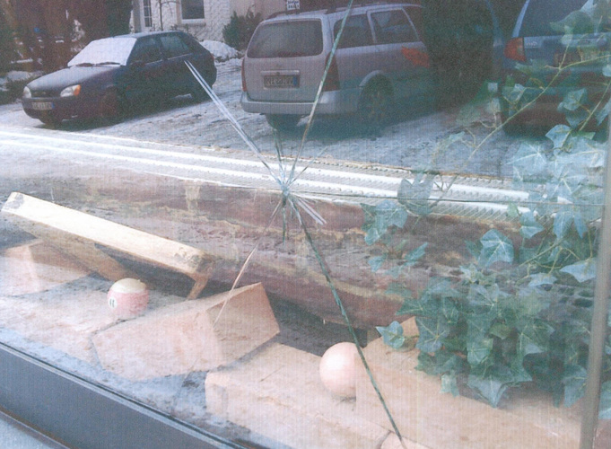 Bild 01: Die gebrochene Scheibe der Spielothek: Ansicht des Bruchausgangs mit vom Zentrum sternförmig auseinanderlaufenden Glassprüngen. - IGA/Wolf-Dietrich Chmieleck