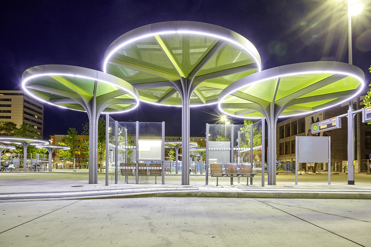 Nachts leuchten Lichtbänder im umlaufenden Stahlrand die Wartebereiche gleichmäßig aus. - Glas Trösch