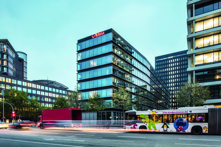 Die transparente Glasfassade des Hotelneubaus greift die Gestaltung des Bestandes auf. - Schüco International KG // Fotograf: Felix Löchner