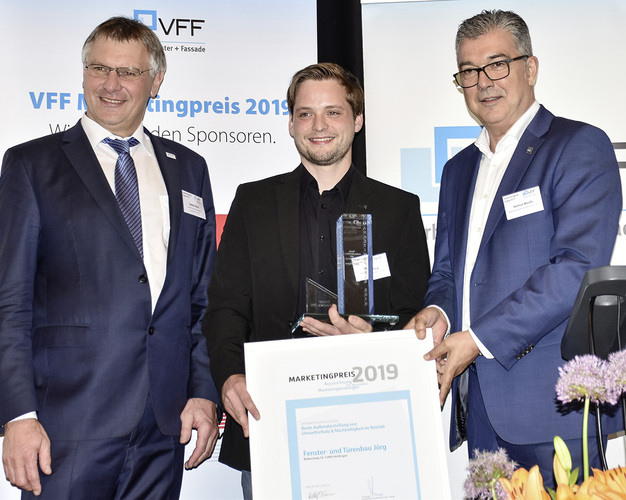 Der Marketingpreis 2019 zum Thema Nachhaltigkeit wurde dem Unternehmen Fensterbau Jörg in Hüttingen bei Aalen verliehen. Nicolai Jörg von der Inhaberfamilie nahm den Preis natürlich gerne entgegen. Auf dem Podium gab es zwischen Helmut Meeth und Nicolai Jörg ein Feilschen um die VFF-Mitgliedschaft des Betriebes: Jörg stellte diese in Aussicht, wenn der Verband seinerseits den Mitgliedsbeitrag in CO2-Projekte anlege. - Daniel Mund / GLASWELT