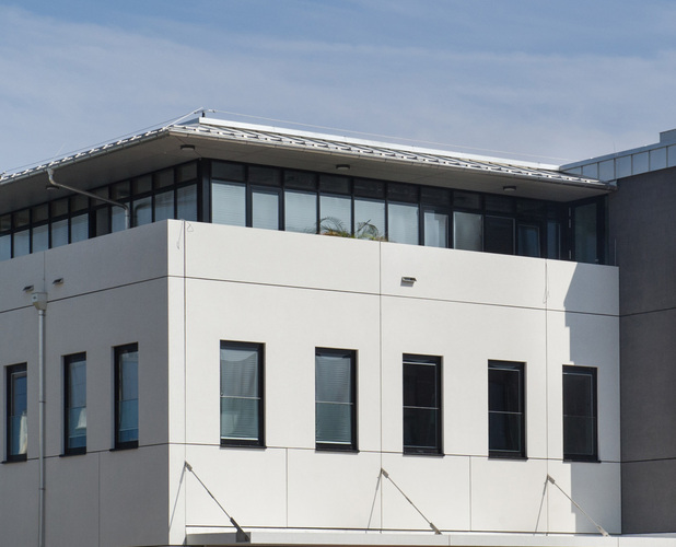 Die Optik der schwarzen Pfosten-Riegel-Konstruktion im OG wird durch den im Isolierglas integrierten Sonnenschutz nicht gestört. - Glastec Rosenheim