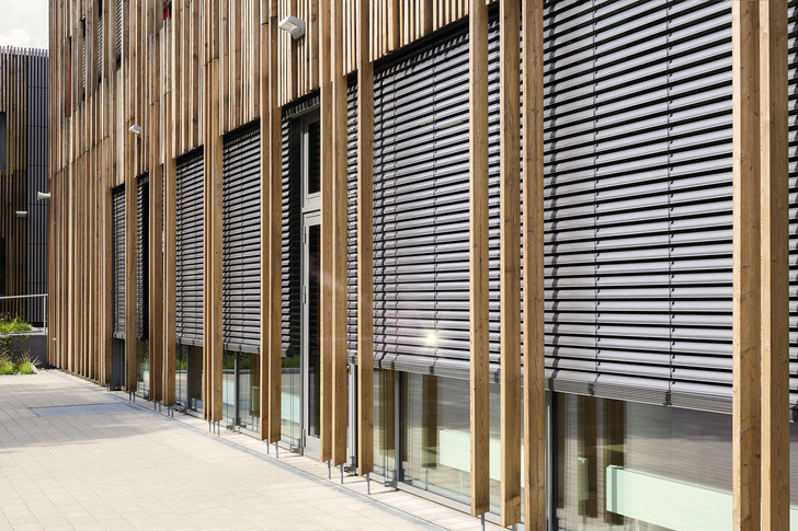 Die vom Architektur- und Ingenieurbüro pbr Planungsbüro Rohling AG ausgeführte Grundschule Rahewinkel passt sich mit seiner Holzfassadenkonstruktion der parkähnlichen Natur optisch an.