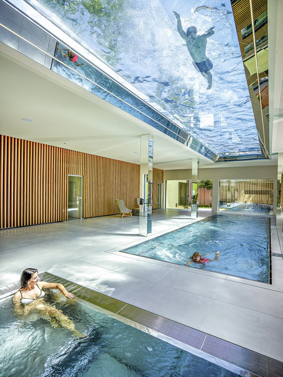 Ein Dach aus Glas und Wasser: der durchsichtige Boden des Pools bietet ein besonderes Schwimmerlebnis und sorgt durch das Wasser im Gebäudeinneren für ganz besondere Lichtspiele.