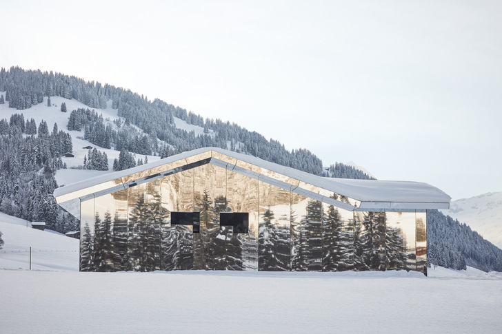 Bei diesem Gebäude in Gstaad (CH) erzeugen die Spiegelflächen der Fassaden für den Betrachter ein kaleidoskopisches Bergpanorama. Gleichzeitig löst sich das Bauwerk optisch als solches auf und wird Teil der umgebenden Landschaft, die es reflektiert.﻿ - © Foto: Torvioll Jashari
