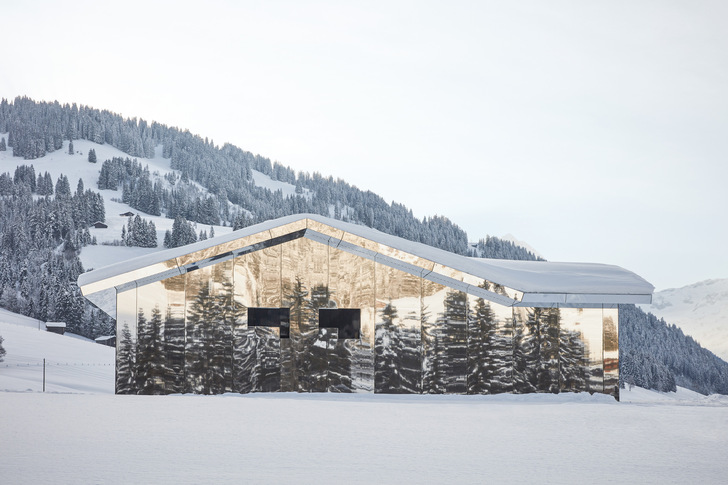 Bei diesem Gebäude in Gstaad (CH) erzeugen die Spiegelflächen der Fassaden für den Betrachter ein kaleidoskopisches Bergpanorama. Gleichzeitig löst sich das Bauwerk optisch als solches auf und wird Teil der umgebenden Landschaft, die es reflektiert.﻿