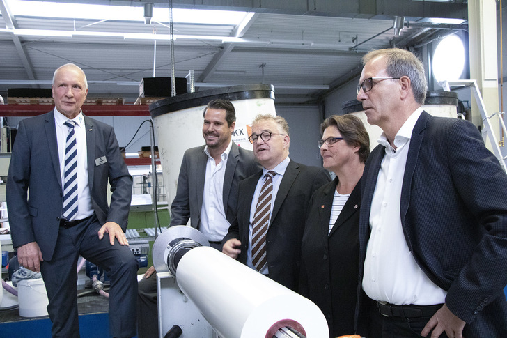 Günter Krohn zeigt Gesellschafter Nicolas Mohr, Regionspräsident Hauke Jagau, Ortsbürgemeisterin Silke Rehmert und Bürgermeister Jürgen Köhne (von links nach rechts) die Herstellung von Hanno Klebstoffen, die beispielsweise für Folienbänder genutzt werden.